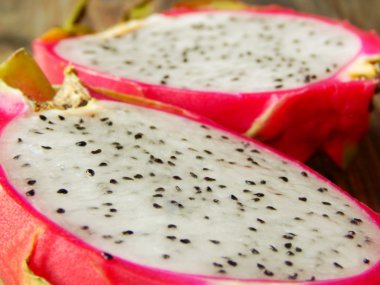 ahşap masa portre üzerinde iki adet sulu pembe pitaya kesilmiş