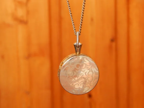 Beautiful silver necklace in a shape of circle on wooden background — Stock Photo, Image