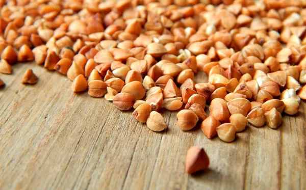 Buckwheat grains on wooden table — Stock Photo, Image