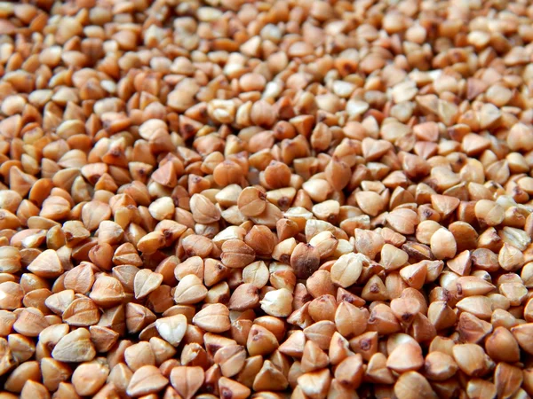 Grãos de trigo mourisco na mesa de madeira — Fotografia de Stock