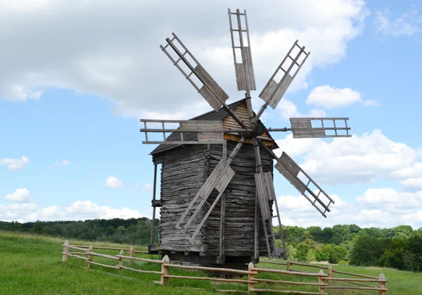 明るく青い空と雲の上の古い木製風車 — ストック写真