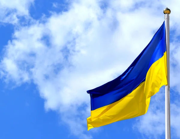 Nationella gul och blå flagga Ukraina över himlen och molnen — Stockfoto
