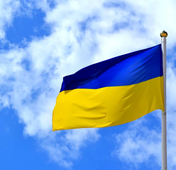 Nationella gul och blå flagga Ukraina över himlen och molnen — Stockfoto