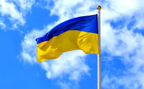 The national yellow and blue flag of Ukraine over the sky and clouds — Stock Photo, Image