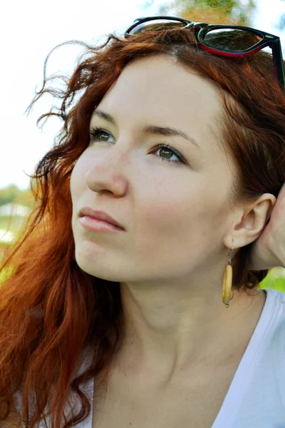 Beautiful young redhead woman looking away and thinking — Stock Photo, Image