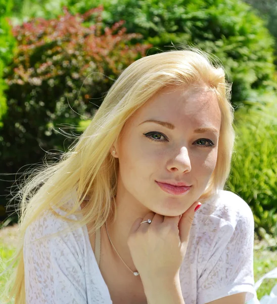 Junge schöne blonde Frau mit langen Haaren, die verschmitzt lächelt — Stockfoto