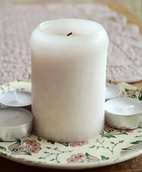 Große weiße Kerze auf einem kleinen Teller — Stock fotografie