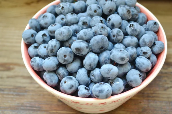 Healthy and delicious blueberries in a bowl on a wooden table — Stock Photo, Image