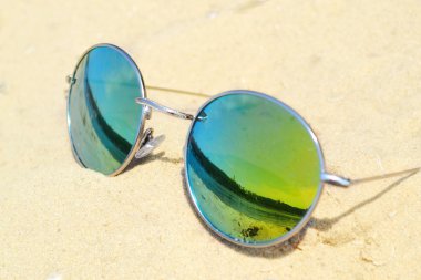 kum plaj yansımasıyla birlikte üzerinde yansıtılmış güneş gözlüğü