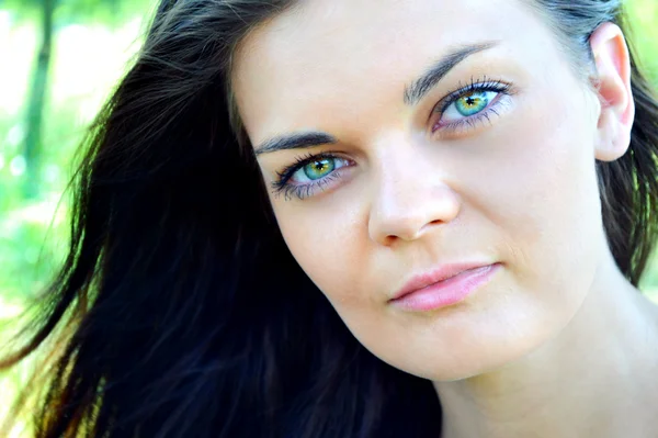 Junge und schöne brünette Frau mit leuchtend grünen Augen — Stockfoto