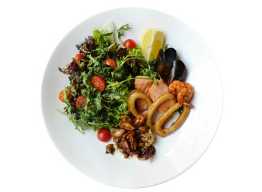 Büyük tabak beyaz izole deniz ürünleri salatası ile