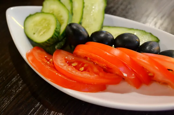 Tomates, concombres et olives dans une assiette — Photo