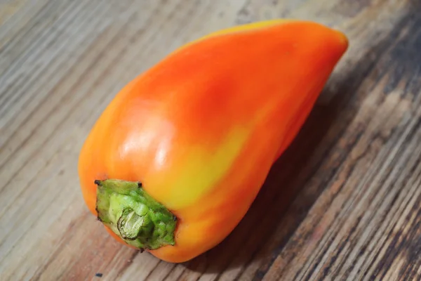 Söta röda och orange paprika på trä bakgrund — Stockfoto
