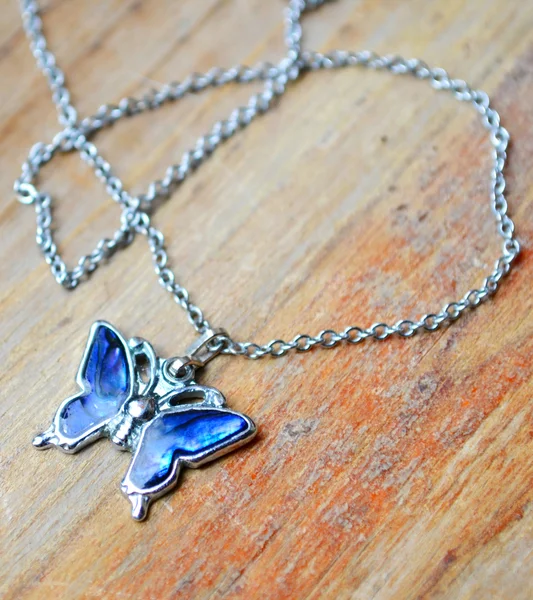 Hermoso collar de plata en forma de mariposa con gemas azules sobre fondo de madera —  Fotos de Stock