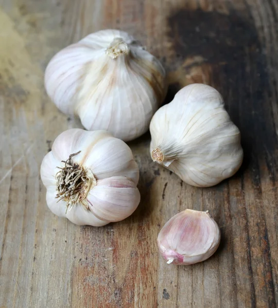 Whole organic garlic and cloves on wooden background — Stock Photo, Image