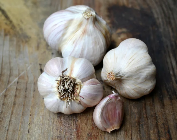 Whole organic garlic and cloves on wooden background — Stock Photo, Image