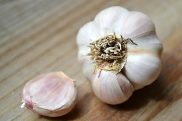 Whole organic garlic and cloves on wooden background — Stock Photo, Image