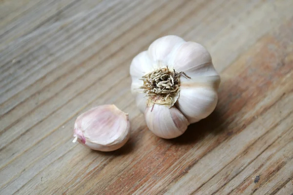 Whole organic garlic and cloves on wooden background — Stock Photo, Image