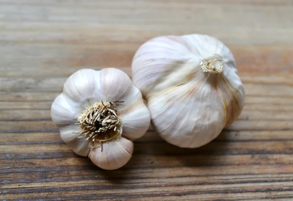 Ganzer Bio-Knoblauch und Nelken auf Holzgrund — Stockfoto