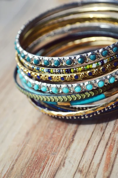 Beaux bracelets en or coûteux sur fond en bois — Photo