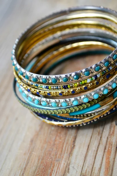 Hermosas pulseras de oro caros sobre fondo de madera —  Fotos de Stock