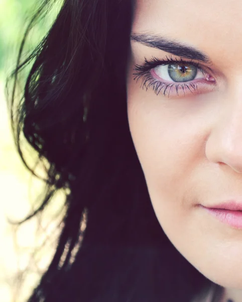 Young and beautiful brunette woman with bright green eye looking mysteriously — Stock Photo, Image