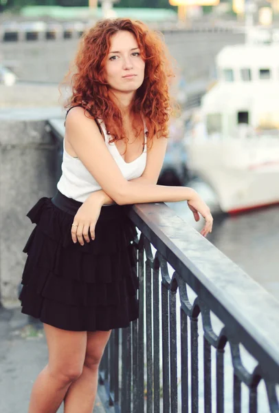 Beautiful young redhead woman in a fashionable dress looking bored — Stock Photo, Image