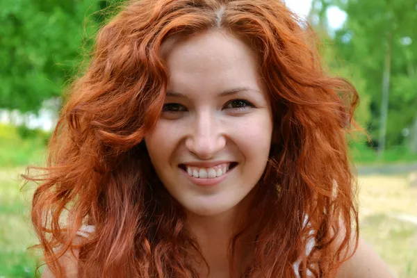 Mutlu bir şekilde gülümseyen güzel genç Kızıl saçlı kadın — Stok fotoğraf