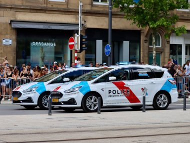 Police cars driving on National day parade. Luxembourg, Luxembourg - June 23, 2022. Selective focus