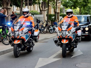 Two police motorcycles escorting black Daimler Limousine car to National day parade. Luxembourg, Luxembourg - June 23, 2022. Selective focus