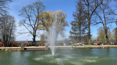 May park rotating fountain splashing water on a bright spring day. Cesis, Latvia - May 1, 2022 