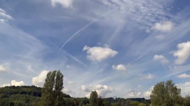 Time lapse of fluffy white clouds rolling in over blue sky after a long sunny spell and draught
