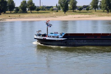 Güneşli bir yaz gününde Ren nehrinde kargo botları, uzun hava akımından dolayı düşük su koşulları. Düsseldorf, Kuzey Ren-Vestfalya, Almanya - 2 Eylül 2022