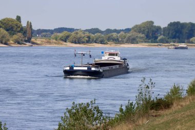 Güneşli bir yaz gününde Ren nehrinde kargo botları, uzun hava akımından dolayı düşük su koşulları. Düsseldorf, Kuzey Ren-Vestfalya, Almanya - 2 Eylül 2022