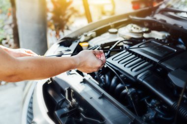 Otomobil tamircisinin elleri garajdaki yağ seviyesini kontrol ediyor. Araba tamirhanesi konsepti.