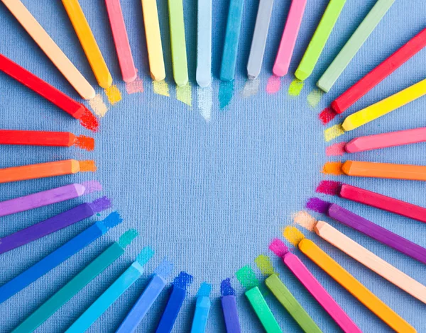 Colorful chalk pastels in shape of heart — Stock Photo, Image