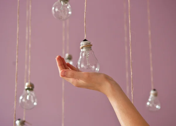 Close up image of human hand holding hanging  bulb — Stock Photo, Image