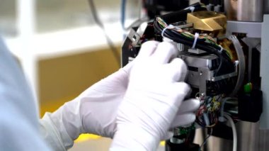 Eldivenli eller elektron mikroskobundan örnek alıyor.