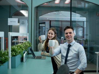 İş kadını, erkek, kadın, yetişkin, mutlu bir şekilde oturan insanlar gülümseyerek kameraya, kahve fincanına, kahveye, kafeye, ofis içi, sınıf ilişkisi ortaklığına bakar.