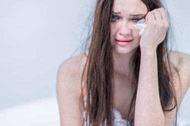 Depresyon. Kırık kalp. Sinirlen. Kalbi kırılmış. Kötü haberi al. Acı çekmek için. Maskaradan yüzü kirlenmiş bir kadın yatağa oturur, ağlar, gözyaşlarını siler..