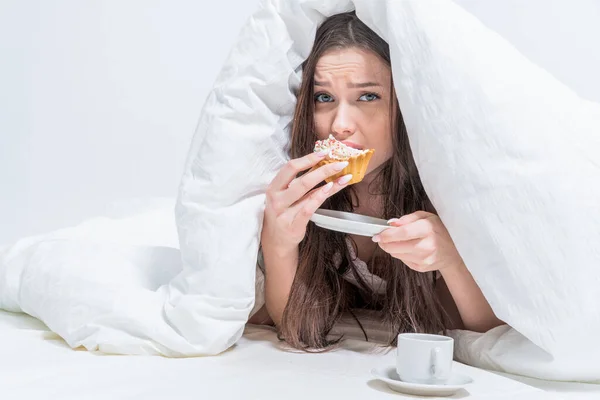 Eine Süße Frau Isst Einen Cupcake Liegt Auf Dem Bett — Stockfoto