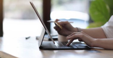 Bilgisayarında hesap makinesi ve kredi kartı olan bir kadın online alışveriş yapıyor.