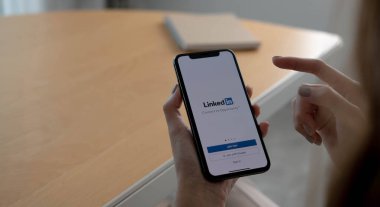 CHIANG MAI, THAILAND, OCT 12, 2021: Bir kadın ekranda LinkedIn uygulamalı Apple iPhone X 'leri tutuyor. LinkedIn akıllı telefonlar için fotoğraf paylaşım uygulaması