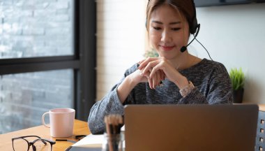 Asyalı bir kadının evinden internetten ders çalışmasını, öğrenci mesafesini not almasını laptoptan öğrenmesini, ödev yapmasını, video dersi izlemesini. Uzaktan eğitim kavramı