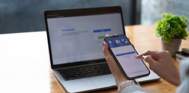 CHIANG MAI, THAILAND OTC 18 2021: Ekranda sosyal internet servis Facebook 'u olan iPhone 13 Pro Max' i tutan kadın