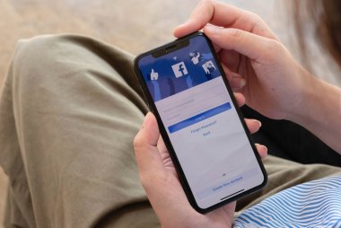CHIANG MAI, THAILAND 7 2021: Sosyal İnternet hizmet Facebook 'u olan iPhone X' i elinde tutan kadın