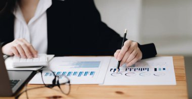 Finansal konsepte danış. İş kadını kağıt işlerini işaret ediyor ve hesap makinesi kullanıyor.