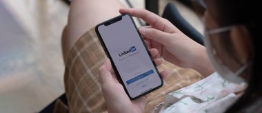 CHIANG MAI, THAILAND, 14 Kasım 2021: Bir kadın ekranda LinkedIn uygulaması ile Apple iPhone X tutuyor. LinkedIn akıllı telefonlar için fotoğraf paylaşım uygulaması