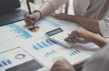 Finans, vergi, muhasebe, istatistik ve analitik araştırma konseptini hesaplamak için hesap makinesi ve dizüstü bilgisayar kullanarak iş adamı ve ortağını kapat