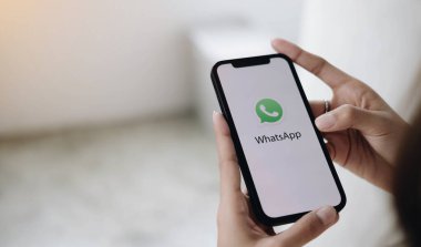 CHIANG MAI, THAILAND - LAN 10 2022: bir adam iPhone tutuyor ve açık apstore arama sosyal internet hizmeti WhatsApp ekranda. iPhone Apple tarafından oluşturuldu ve geliştirildi.